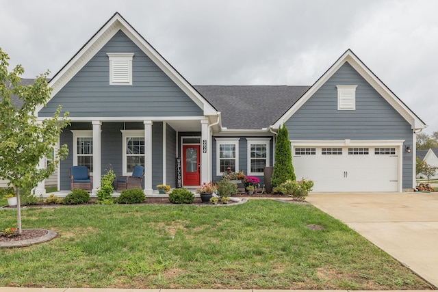 view of front of property featuring covered porch, a front yard, and a garage