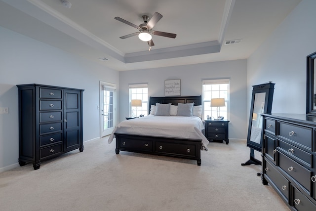 carpeted bedroom with ceiling fan, a raised ceiling, and crown molding