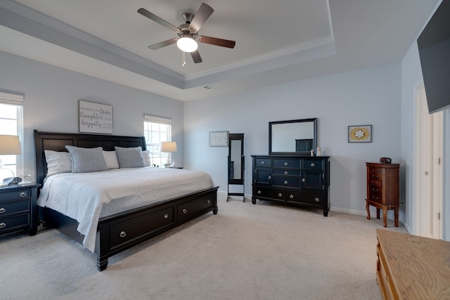 carpeted bedroom featuring crown molding, a tray ceiling, and ceiling fan