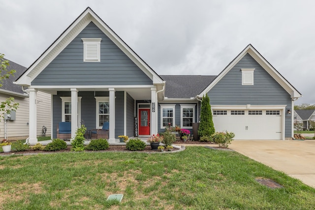 view of front facade featuring a front yard, a garage, and a porch