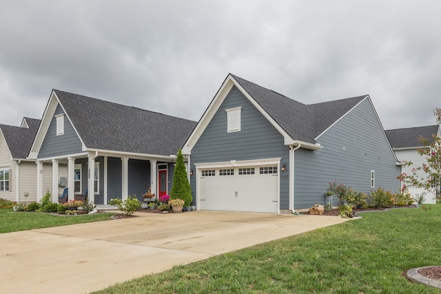 view of front facade featuring a front lawn, covered porch, and a garage