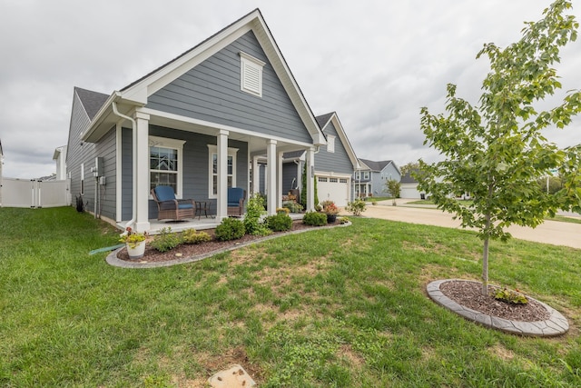 view of front of house featuring a front yard, a garage, and covered porch