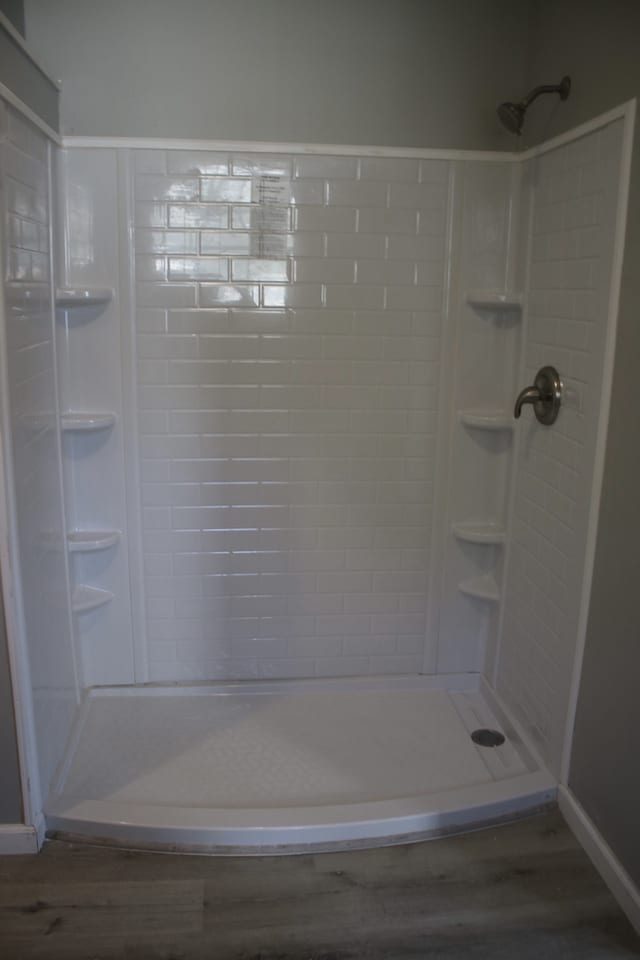 bathroom featuring hardwood / wood-style flooring and tiled shower