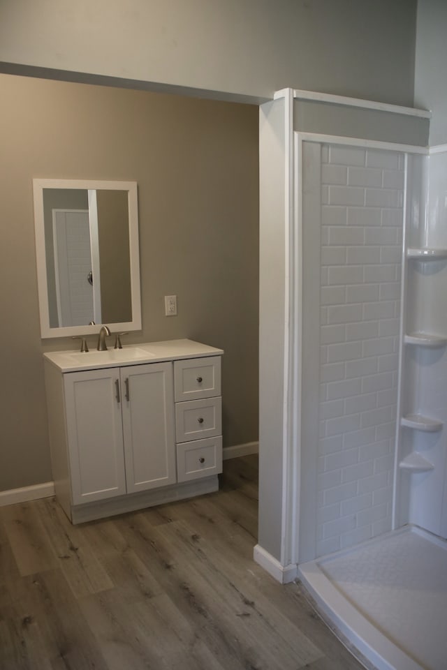 bathroom featuring walk in shower, vanity, and hardwood / wood-style flooring