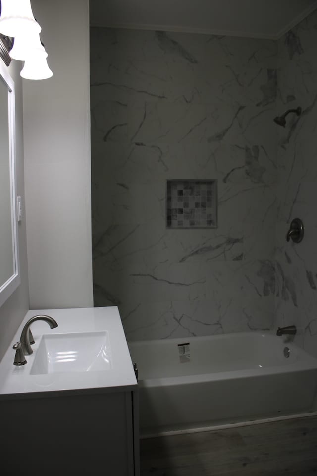 bathroom featuring ornamental molding, hardwood / wood-style floors, shower / bathtub combination, and vanity