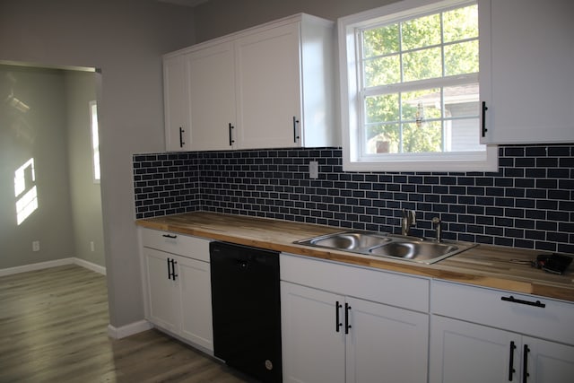 kitchen with butcher block countertops, black dishwasher, sink, and white cabinetry