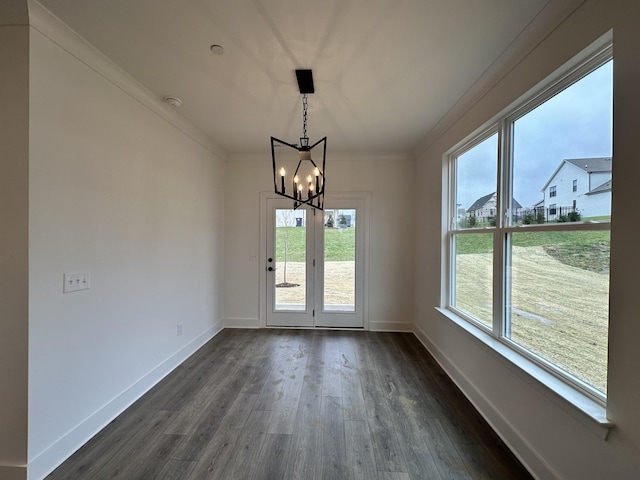 interior space featuring dark hardwood / wood-style flooring, ornamental molding, and an inviting chandelier