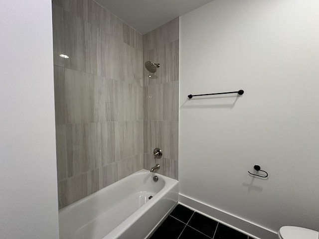 bathroom featuring toilet, tile patterned flooring, and tiled shower / bath