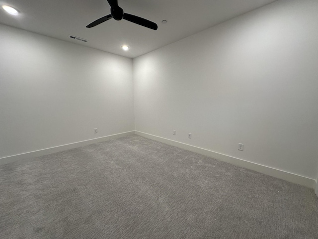 empty room featuring ceiling fan and carpet