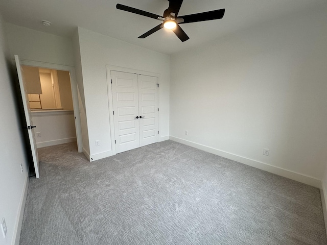 unfurnished bedroom featuring carpet, ceiling fan, and a closet