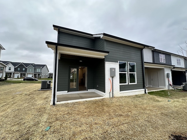 back of property with a yard and central air condition unit