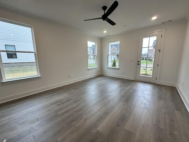 spare room with ceiling fan, dark wood-type flooring, and a healthy amount of sunlight