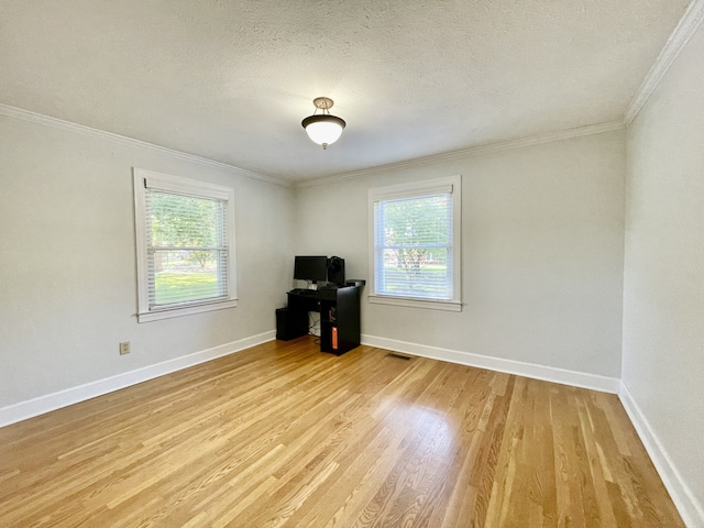 spare room featuring a textured ceiling, crown molding, and light hardwood / wood-style flooring