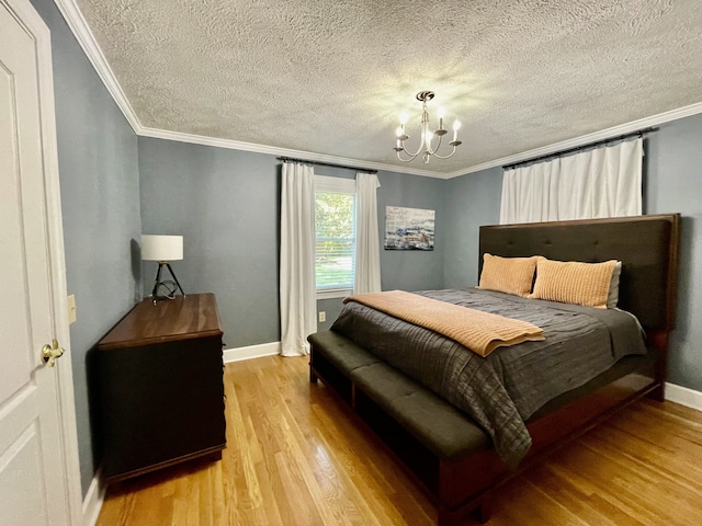 bedroom with ornamental molding, light hardwood / wood-style floors, a textured ceiling, and a chandelier