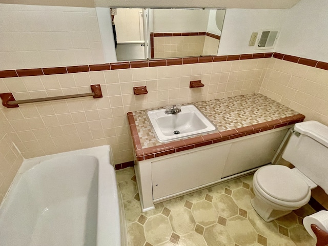 bathroom with toilet, a washtub, vanity, and tile walls