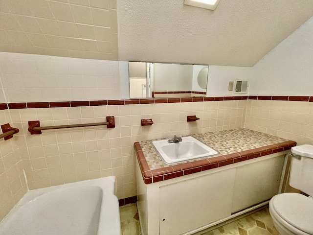 bathroom with tile patterned flooring, vanity, toilet, a bathtub, and tile walls