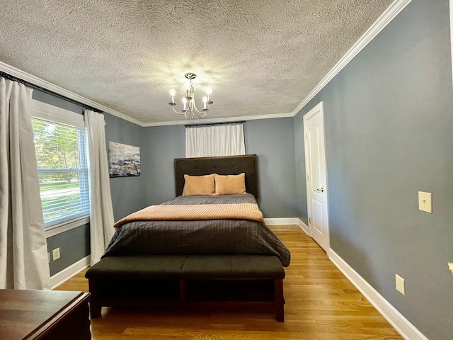 bedroom with wood-type flooring, a textured ceiling, an inviting chandelier, and ornamental molding