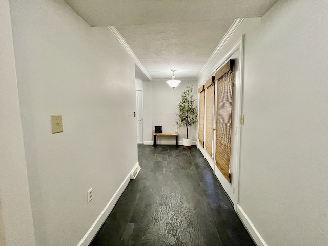 hall featuring a textured ceiling, dark hardwood / wood-style floors, and crown molding