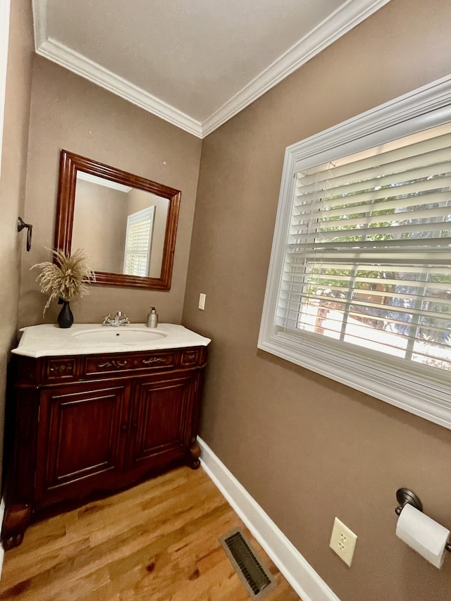 bathroom with hardwood / wood-style floors, vanity, and ornamental molding