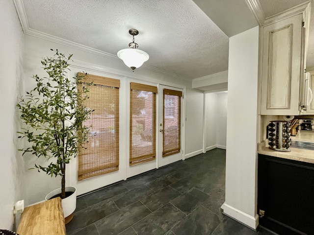 entryway with a textured ceiling and crown molding