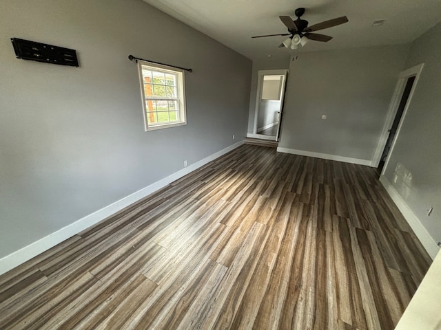 empty room with ceiling fan and dark wood-type flooring