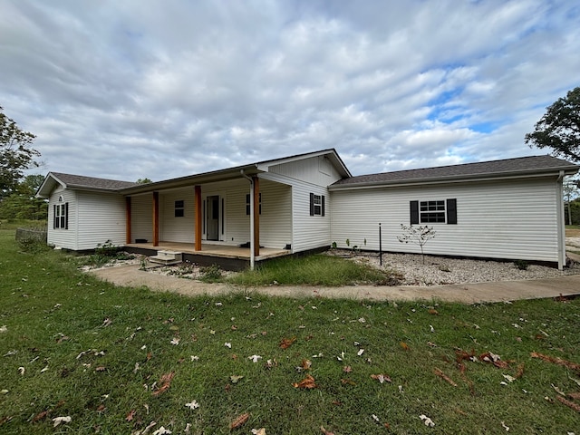 back of property with a lawn and covered porch