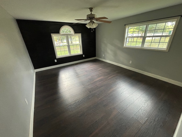 spare room with dark wood-type flooring and ceiling fan