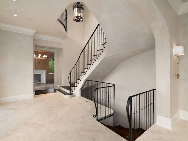 staircase featuring crown molding and a notable chandelier