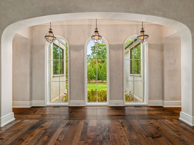 unfurnished dining area with a wealth of natural light and dark hardwood / wood-style flooring