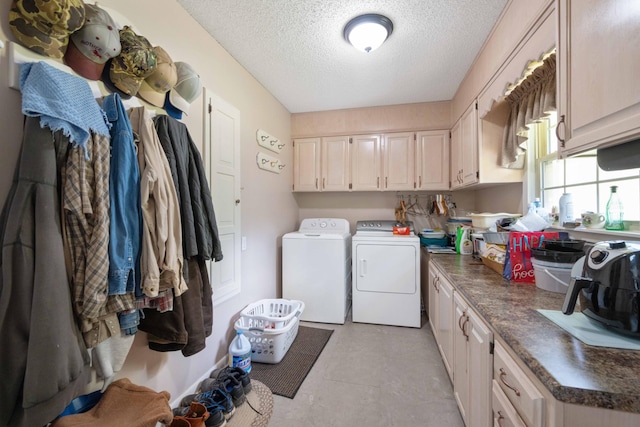 clothes washing area featuring a textured ceiling, cabinet space, and washer and dryer