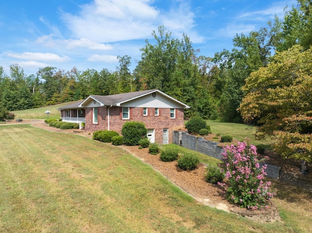 view of front of home featuring a front lawn, brick siding, and a garage