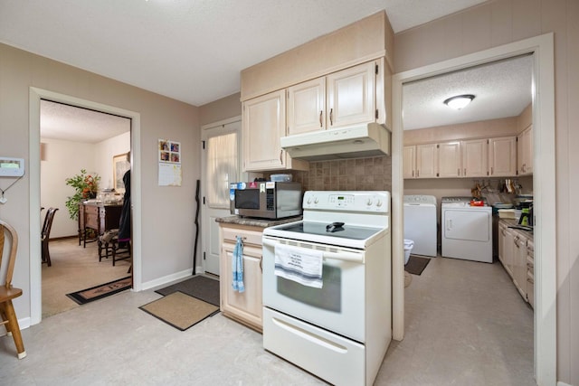 kitchen with stainless steel microwave, a textured ceiling, under cabinet range hood, separate washer and dryer, and white range with electric cooktop