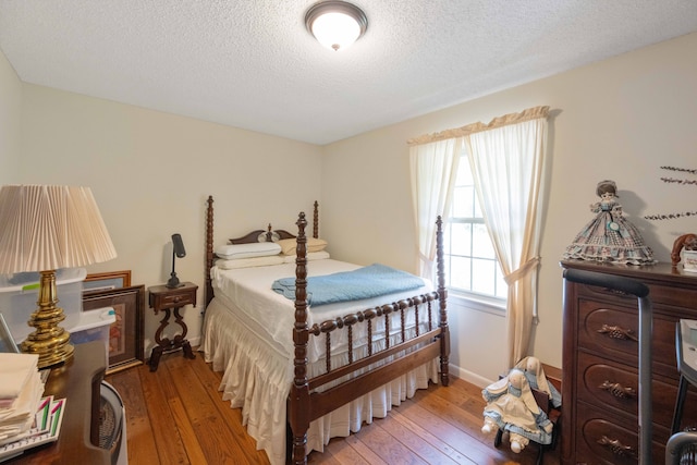 bedroom with light hardwood / wood-style floors and a textured ceiling