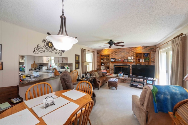 dining space with ceiling fan, brick wall, a healthy amount of sunlight, and a textured ceiling