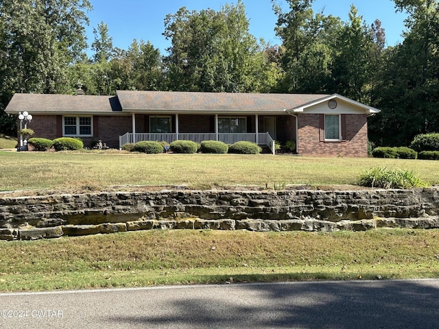 view of front of home featuring a front lawn, brick siding, and covered porch