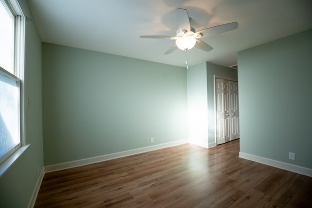 spare room featuring ceiling fan and dark wood-type flooring