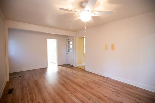 empty room featuring crown molding, light hardwood / wood-style flooring, and ceiling fan