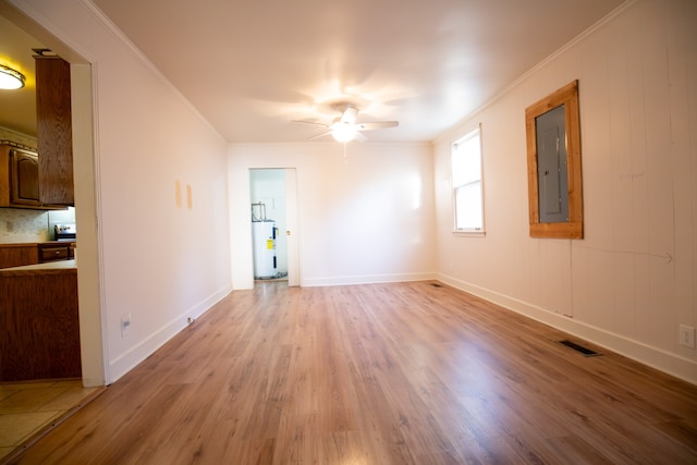 unfurnished room with electric panel, electric water heater, ceiling fan, crown molding, and light hardwood / wood-style floors