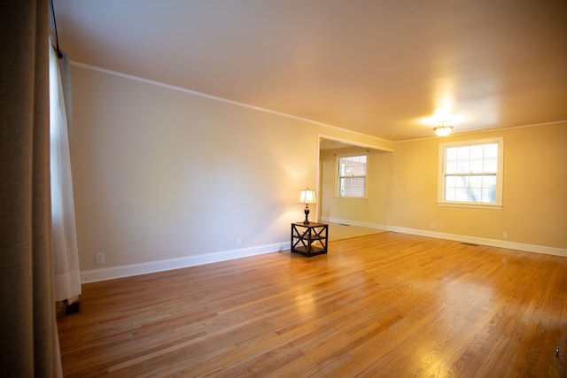 unfurnished room featuring hardwood / wood-style flooring and crown molding