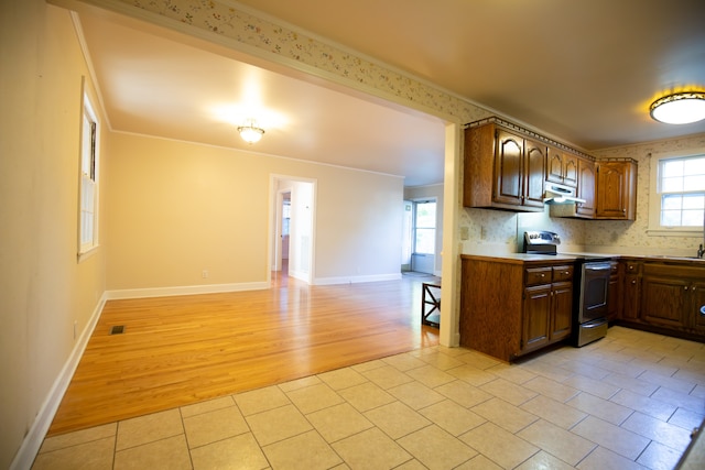 kitchen featuring tasteful backsplash, light hardwood / wood-style floors, stainless steel electric stove, and crown molding