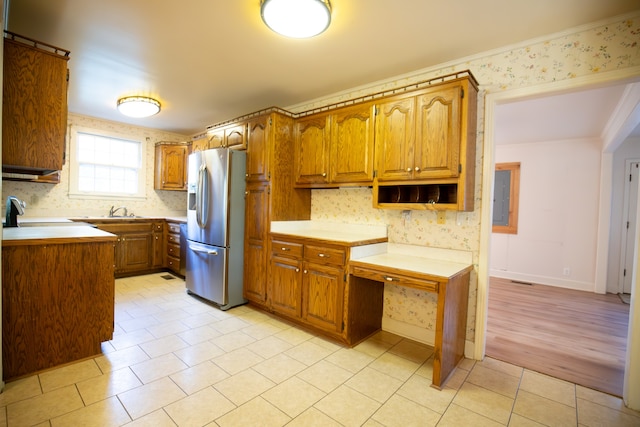 kitchen with stainless steel refrigerator with ice dispenser, light wood-type flooring, sink, range, and electric panel