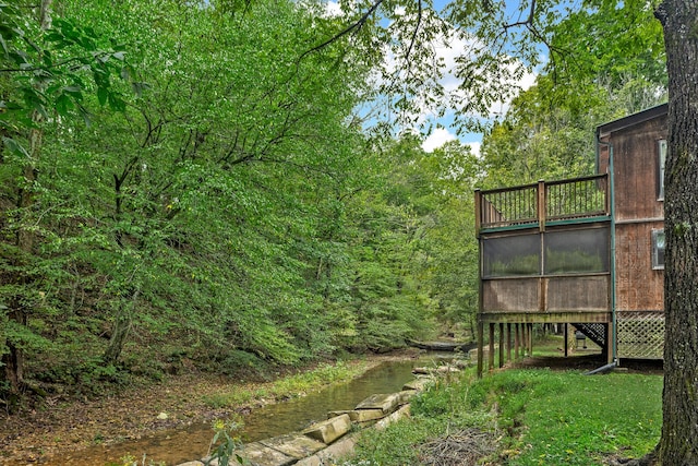 view of yard featuring a water view and a sunroom