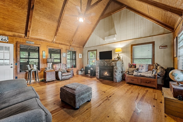 living room with ceiling fan, beamed ceiling, light wood-type flooring, and a fireplace