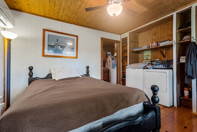 bedroom featuring wood ceiling, wood-type flooring, an AC wall unit, independent washer and dryer, and ceiling fan