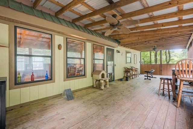 sunroom with ceiling fan and beamed ceiling