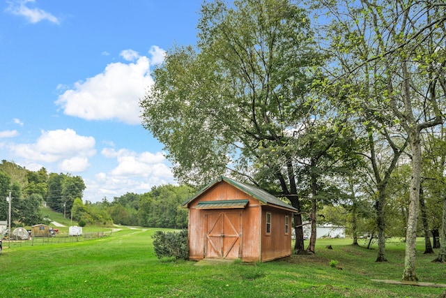 view of outdoor structure featuring a lawn and a water view