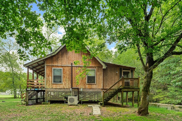 back of house featuring a deck, ac unit, and a yard