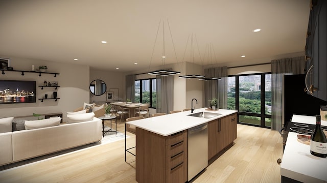 kitchen with a breakfast bar area, an island with sink, stainless steel dishwasher, light wood-type flooring, and sink