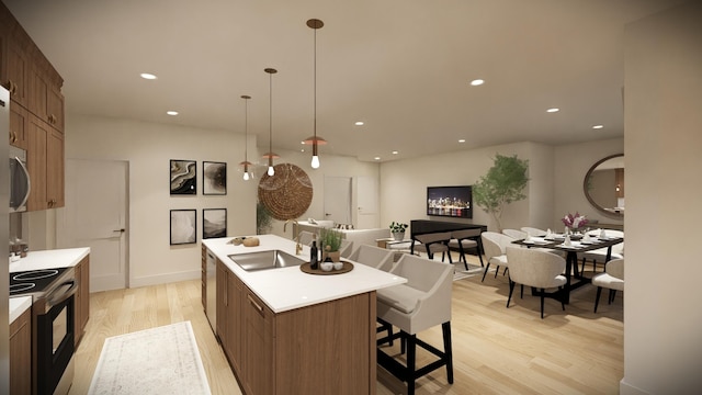 kitchen with an island with sink, sink, light wood-type flooring, and electric stove