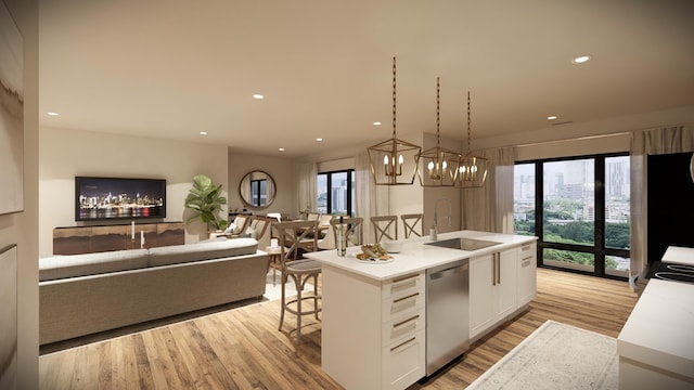 kitchen with a kitchen island with sink, light hardwood / wood-style flooring, hanging light fixtures, stainless steel dishwasher, and white cabinets